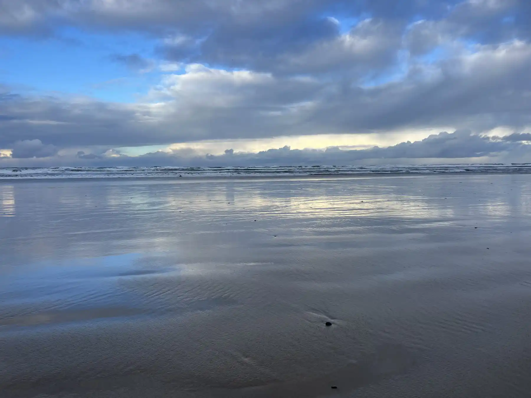 Sky reflected on wet sand at the beach